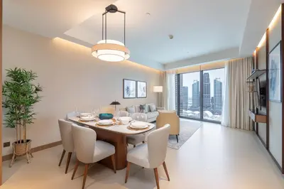 a dining room and living room with a table and chairs at Address Residences Dubai Opera - Burj Khalifa City Views 1, 2, & 3-Bedroom Apartment 1 minute walk to Burj Khalifa, Dubai Mall, Dubai Fountain by Heaven Crest in Dubai