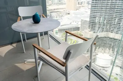 a table and chair with a vase on top of a window at Address Residences Dubai Opera - Burj Khalifa City Views 1, 2, & 3-Bedroom Apartment 1 minute walk to Burj Khalifa, Dubai Mall, Dubai Fountain by Heaven Crest in Dubai