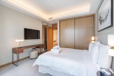 a hotel room with a bed and a television at Address Residences Dubai Opera - Burj Khalifa City Views 1, 2, & 3-Bedroom Apartment 1 minute walk to Burj Khalifa, Dubai Mall, Dubai Fountain by Heaven Crest in Dubai