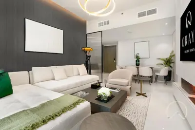 a living room with a white couch and a table at Oraya - Upgraded 2BR In Prive Maison, Central Canal View in Dubai