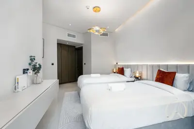 two beds in a bedroom with white walls at Oraya - Upgraded 2BR In Prive Maison, Central Canal View in Dubai