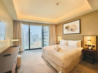a hotel room with a bed and a large window at Vista Luxe 3 Bedroom at Address Opera I Burj Khalifa & Fountain Views in Dubai