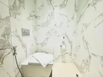 a white bathroom with a marble wall at Vista Luxe 3 Bedroom at Address Opera I Burj Khalifa & Fountain Views in Dubai