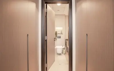 a bathroom with a toilet and a hallway at Modern JVC 1BR with Spacious Terrace in Dubai