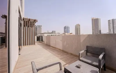 a balcony with two chairs and a bench on a building at Modern JVC 1BR with Spacious Terrace in Dubai