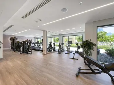 a gym with several treadmills and ellipticals in a room at 5 Minute Walk to The Fountains! Full Burj Khalifa View! 5-star Pool & Gym! in Dubai