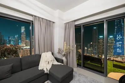 a living room with a couch and a large window at 5 Minute Walk to The Fountains! Full Burj Khalifa View! 5-star Pool & Gym! in Dubai