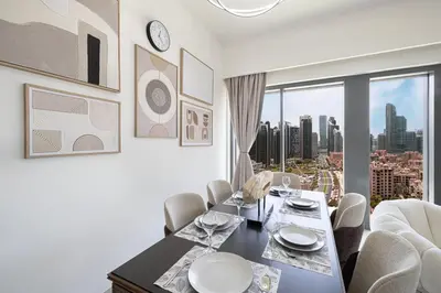a dining room with a table and chairs and a window at 5 Minute Walk to The Fountains! Full Burj Khalifa View! 5-star Pool & Gym! in Dubai