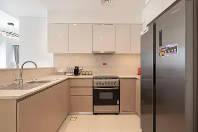 a kitchen with a stove and a refrigerator at 5 Minute Walk to The Fountains! Full Burj Khalifa View! 5-star Pool & Gym! in Dubai