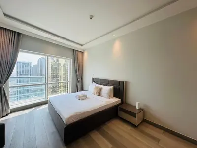a bedroom with a bed and a large window at ModernLux - Brand New Modern 1BR Apartment with Lake View, JLT close to Metro in Dubai