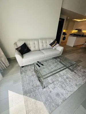 a living room with a white couch and a glass coffee table at ModernLux - Brand New Modern 1BR Apartment with Lake View, JLT close to Metro in Dubai