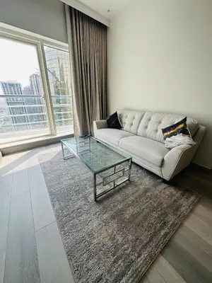a living room with a couch and a glass table at ModernLux - Brand New Modern 1BR Apartment with Lake View, JLT close to Metro in Dubai