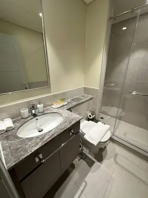 a bathroom with a sink and a shower and a toilet at Incredible View - Fountain show - 4BR - PS5 and Games in Dubai