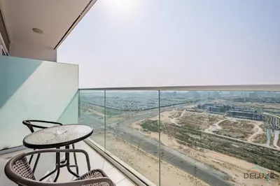 a table and chair on a balcony with a view at Inviting Studio in Damac Hills Carson B, Dubailand by Deluxe Holiday Homes in Dubai