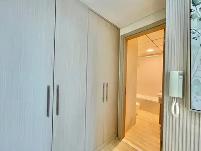 a bathroom with white cabinets and a hallway at Vacay Lettings - Bay Central Tower - Studio in Dubai