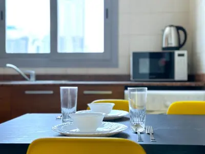a table with plates and bowls and glasses on it at First Line Canal View Studio with Balcony MAX 4 Pax in Dubai