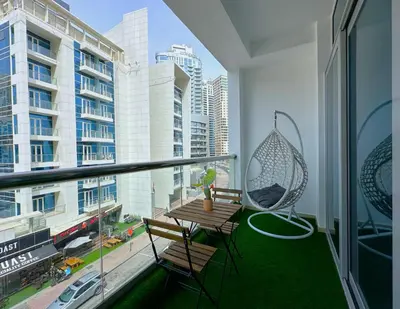a balcony with a swing and a table and chairs at First Line Canal View Studio with Balcony MAX 4 Pax in Dubai