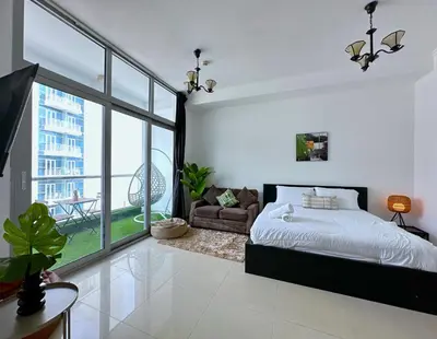 a bedroom with a bed and a large window at First Line Canal View Studio with Balcony MAX 4 Pax in Dubai