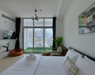 a bedroom with a white bed and a large window at First Line Canal View Studio with Balcony MAX 4 Pax in Dubai