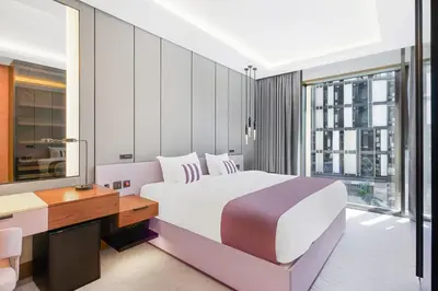 a bedroom with a large bed with a desk and a window at Vonder Bluewaters Residences SA2 in Dubai