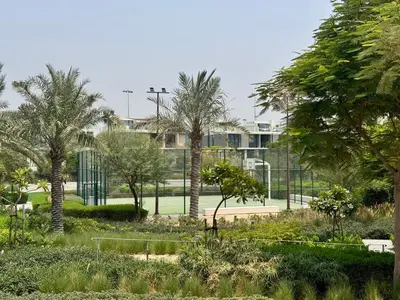 a park with palm trees in front of a building at Chic 1 BR apartment at Golfville in Dubai