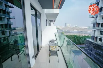 a balcony with a table and chairs on a building at Alashrafia Saray - Bright 1bdr apartment in JVC in Dubai