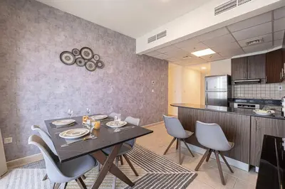 a dining room with a table and chairs in a kitchen at Lux 2BR with Sea Views in Marina in Dubai