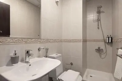 a white bathroom with a sink and a toilet at Lux 2BR with Sea Views in Marina in Dubai