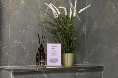 a bottle of wine sitting on a shelf with a plant at Brand New 1BR with Pool, Sauna & Gym in Dubai