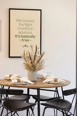 a dining room table with chairs and a picture at Brand New 1BR with Pool, Sauna & Gym in Dubai