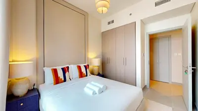 a bedroom with a white bed with two pillows at Locations I Spacious Modern 3 Bedroom I Luxury Stay Near Dubai Mall & Burj Khalifa I Pool, Gym, Parking & Wi-Fi in Dubai