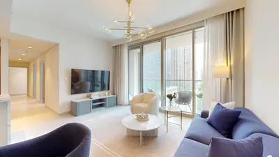 a living room with a blue couch and a tv at Locations I Spacious Modern 3 Bedroom I Luxury Stay Near Dubai Mall & Burj Khalifa I Pool, Gym, Parking & Wi-Fi in Dubai