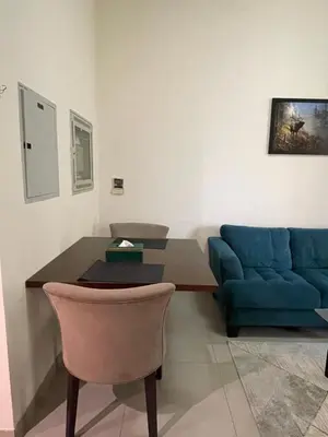 a living room with a blue couch and a table at Homes2Retreat - Studio in Lincoln Park Sheffield in Dubai