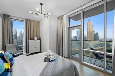 a bedroom with a bed and a large window at Spacious and Peaceful 1BR with Canal views in Dubai