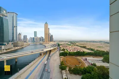a view of a city with a bridge over a river at Spacious and Peaceful 1BR with Canal views in Dubai
