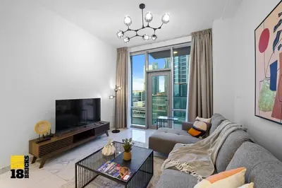 a living room with a couch and a tv at Spacious and Peaceful 1BR with Canal views in Dubai
