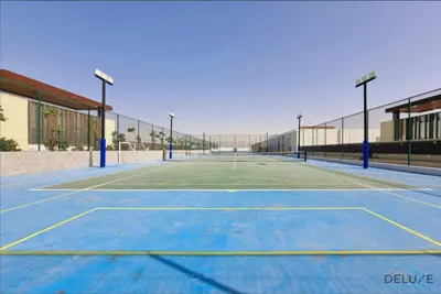 an empty tennis court with lights on it at Stylish 1BR Apartment in Damac Hills 2 Avencia 45, Dubailand by Deluxe Holiday Homes in Dubai
