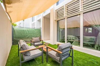 a patio with two chairs and a table at Stylish 1BR Apartment in Damac Hills 2 Avencia 45, Dubailand by Deluxe Holiday Homes in Dubai