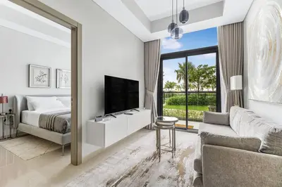 a white bedroom with a bed and a large mirror at Goldbest - Aykon City 2bdr in Dubai