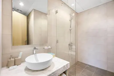 a bathroom with a white sink and a shower at Goldbest - Aykon City 2bdr in Dubai