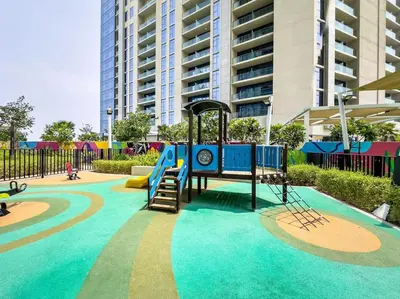 a playground with a slide in a park at Goldbest - Aykon City 2bdr in Dubai