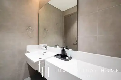 a bathroom with a white sink and a mirror at LUX The Burj Khalifa Lagoon View Suite 2 in Dubai