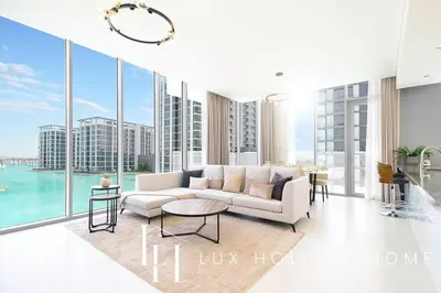 a living room with a white couch and large windows at LUX The Burj Khalifa Lagoon View Suite 2 in Dubai