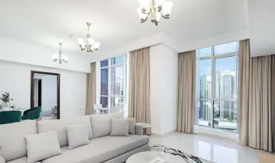 a living room with a white couch and large windows at Majestic Tower in Dubai