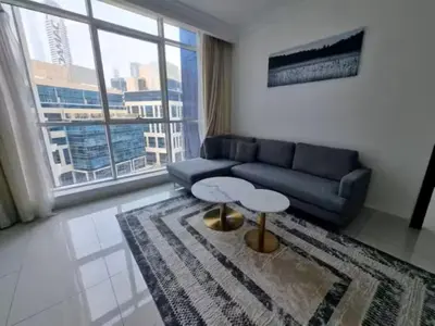 a living room with a couch and a large window at Majestic Tower in Dubai