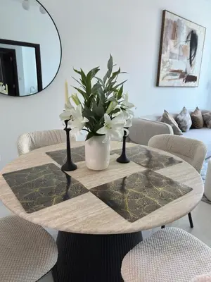 a table with a vase with white flowers on it at Majestic Tower in Dubai
