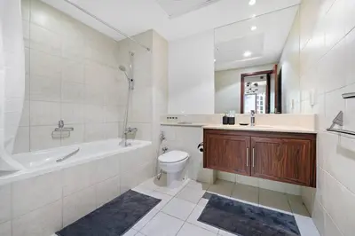 a bathroom with a tub and a toilet and a sink at Spacious 1 BR Apartment Near in Dubai