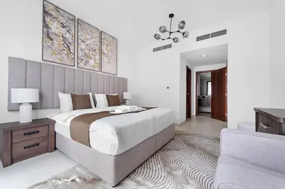 a bedroom with a large bed and a living room at Spacious 1 BR Apartment Near in Dubai