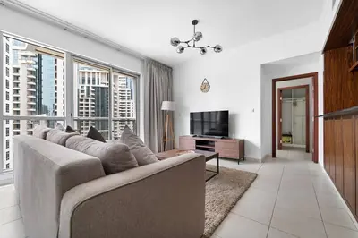 a living room with a couch and a television at Spacious 1 BR Apartment Near in Dubai