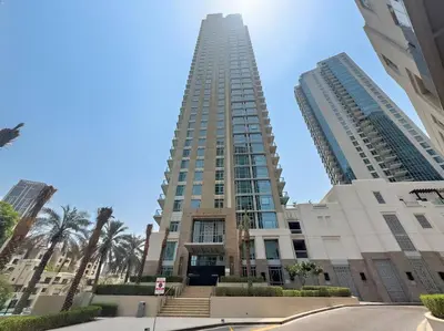 a tall building with palm trees in front of it at Spacious 1 BR Apartment Near in Dubai